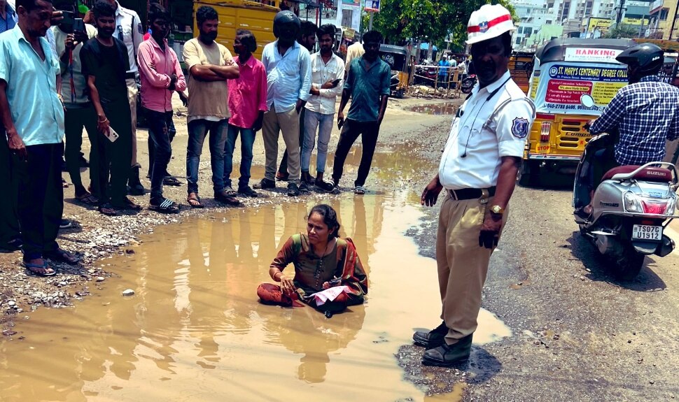 Women Sits In Pothole: రోడ్డు సమస్యపై మౌన నిరసన.. బురదలో కూర్చున్న మహిళ